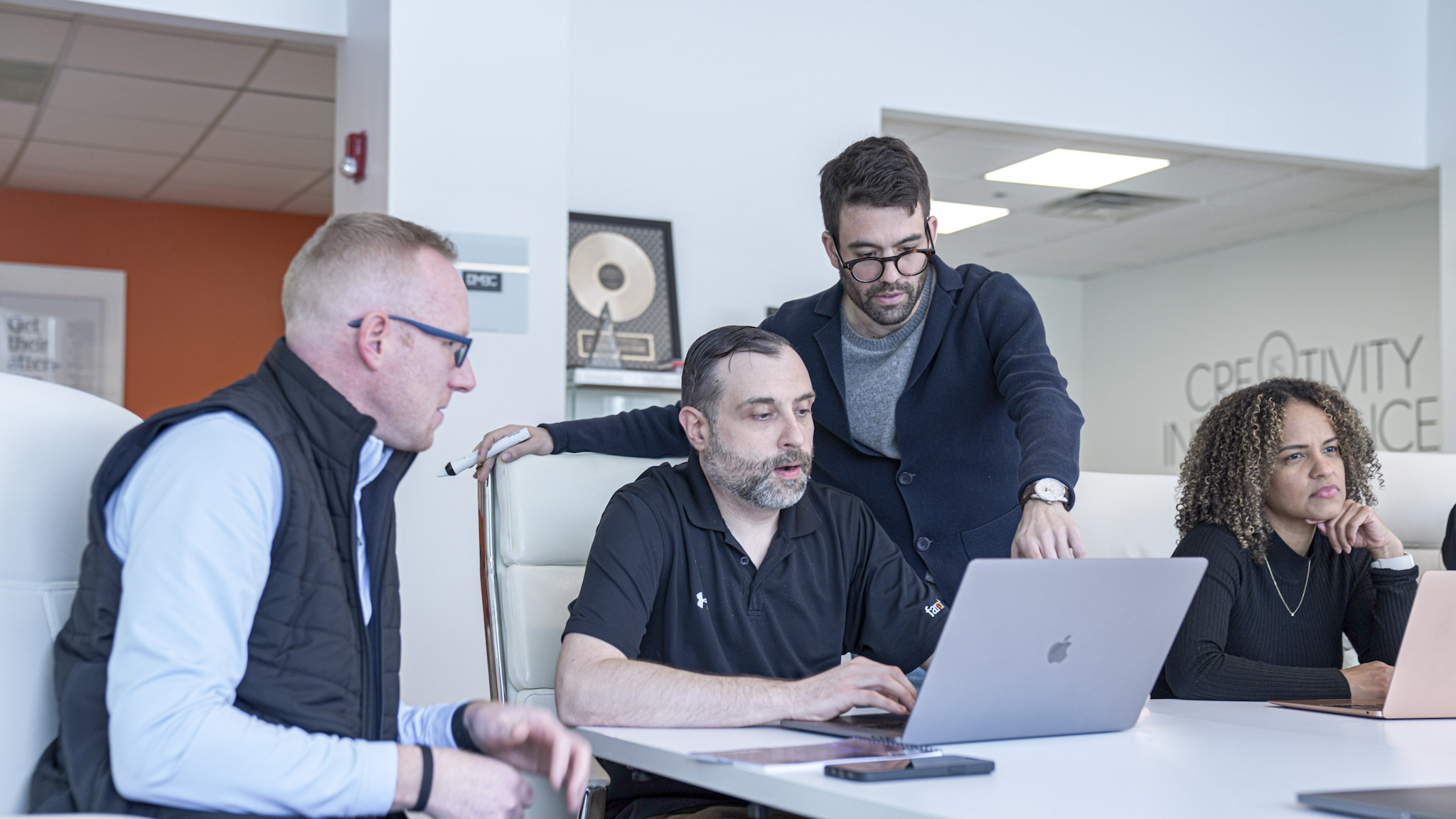 Employees huddling around a computer discussing strategy for social media