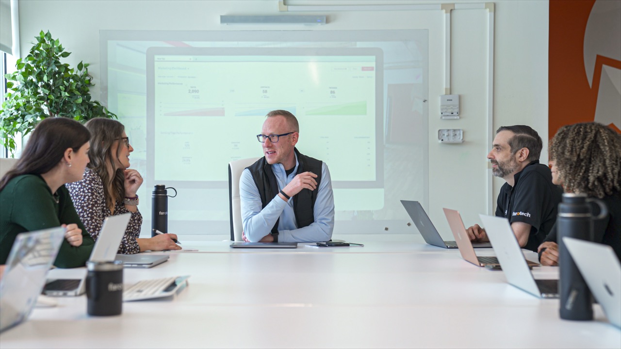 Marketing Professional gives a presentation to a table full of employees